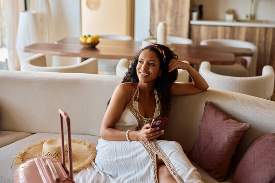 Happy black woman using cell phone while getting ready for summer holiday.