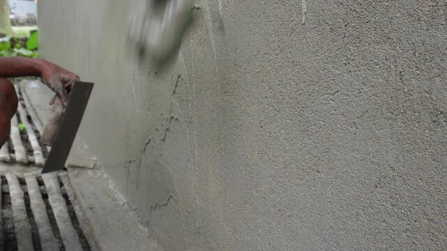 Worker Applying Plaster to Wall with Trowel
