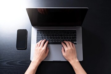 Fototapeta premium Hands Typing on Laptop with Smartphone Nearby
