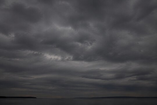Heavy, overcast sky at dusk with thick gray clouds blocking the sun.