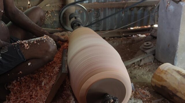 Woodturner Shaping Large Cylindrical Log on Lathe
