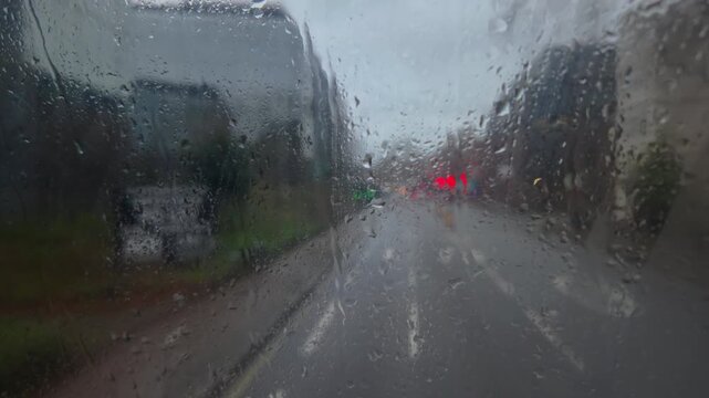 lurred  view of rainy London streets from the upper deck of a public bus