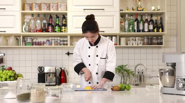 Master pastry chef baker hands in gloves slicing dicing a fresh ripe mango on chopping board for decorate delicious birthday bakery order, ideal for cooking baking, confectionery, culinary, food blogs
