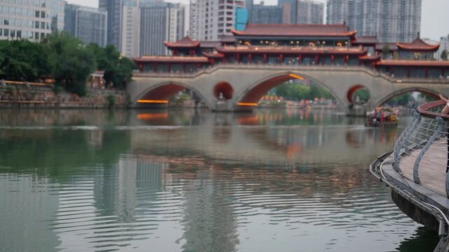 Chengdu Jinjiang Cruise, tourists admiring Anshun Lang Bridge in daytime. Traveling in China, enjoy Asian culture and history, must-visit tourist attraction, showcasing city iconic skyline by boat