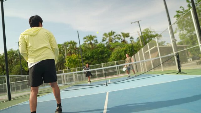Energetic pickleball players practice together on an outdoor court, improving agility, teamwork, fitness, coordination, and healthy lifestyles while enjoying friendly matches, recreation, and memorabl