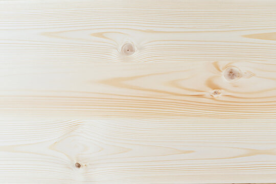 A section of natural light pine wood board with knots and grain