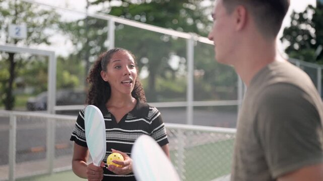 Mixed doubles pickleball team discusses training programs and schedules, joint practice, playing techniques, and how to maintain physical fitness in preparation for field training. Athletes cultivate 