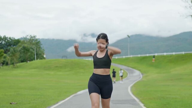 Female runner celebrating after reaching the finish line on a scenic outdoor path, representing fitness achievement, healthy lifestyle, motivation and longevity.