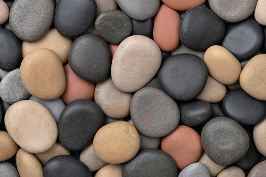 Macro shot of rounded wet river stones of various sizes and colors