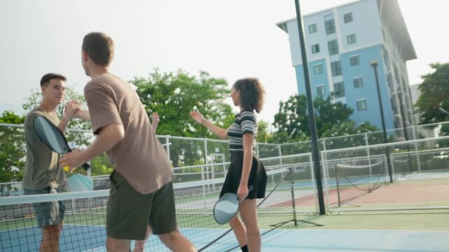 Active pickleball teammates shake hands after an exciting outdoor match, demonstrating respect, teamwork, positive competition, healthy exercise, social connection, and enjoyable recreational activiti