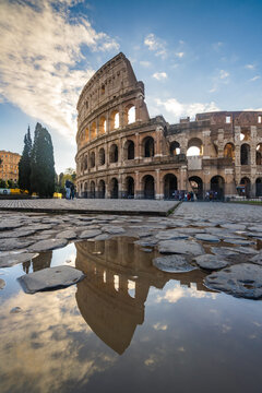 The Colosseum reflected in a puddle at sunset, Rome, Italy