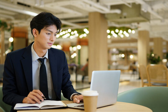 businessman company manager investor working on computer technology sitting at co working office desk. Busy professional businessman executive using laptop at work writing notes.
