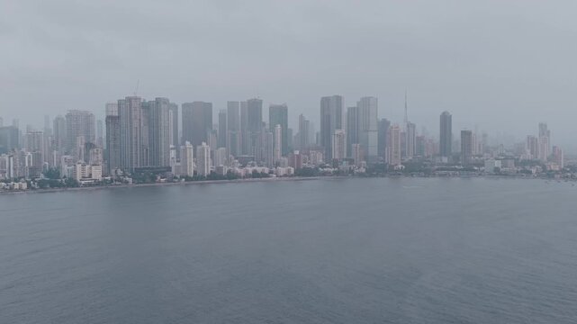 Cinematic drone pull out from Worli skyscrapers and coastal city skyline, Mumbai
