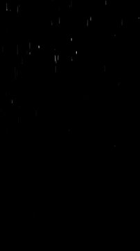 Realistic rainfall falling on an empty black background, vertical video featuring natural rain drops for cinematic overlays, visual effects and compositing