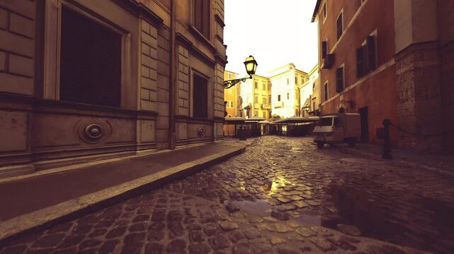 sunset cobblestone lane with bollards and warm glow, long perspective leading to bright horizon, quiet urban scene suitable for travel and lifestyle campaigns