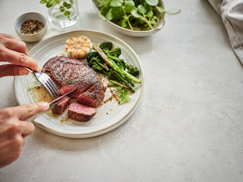 Corte de carne en un plato con verduras y guarnici&oacute;n en una mesa sencilla