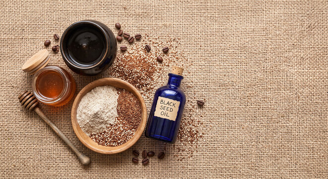 Overhead flat lay of Nigerian shea butter and palm oil skincare on Aso Oke fabric