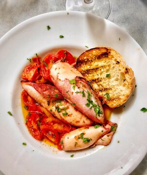 Squid with tomato sauce with bread on plate authentic Italian comfort food.