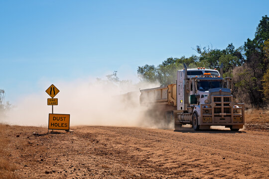 Road train passing dust holes sign in outback Queensland