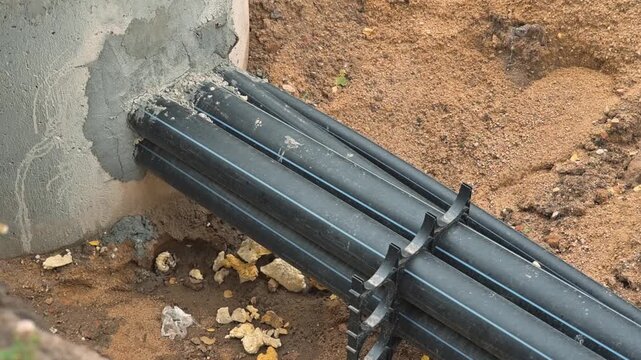 installing a water drainage system using pipes and a concrete base. The project occurs in an outdoor location, showcasing civil engineering techniques