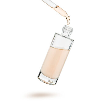 Cosmetic serum gel bottle with dropper in mid-air, isolated on white background.