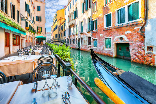 Remarkable  cityscape of Venice with narrow canals, boats and gondolas and bridges with traditional buildings.