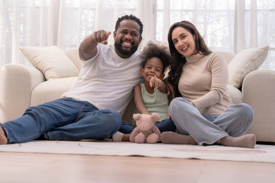 A close blended family bonds on the living room floor during a cozy weekend at home, radiating warmth and connection full of natural candid warmth captured in soft natural light.