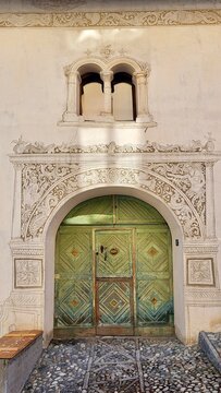 Detailed close-up of a traditional Engadin house door featuring delicate ornamental painted decoration in the historic village of Ardez, Engadin, Switzerland. A beautifully preserved craftsmanship.
