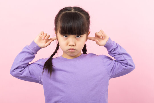 Asian little girl covering ears refusing to listen child ignoring concept