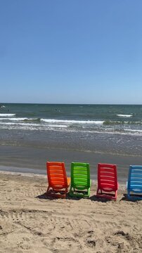 serie di sedie in plastica colorata in riva al mare
