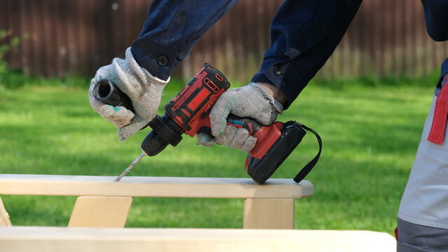 Builder worker using cordless hammer drill. Man with pneumatic perforator equipment making hole at construction. Installation process. Gloved hand grips the tool, precision and safety while working.
