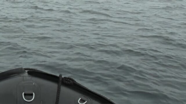 Moving across the boundless, cool Arctic Ocean. A small boat's bow gracefully parts the grey waves, embarking on a silent, serene expedition through the northern wilderness.