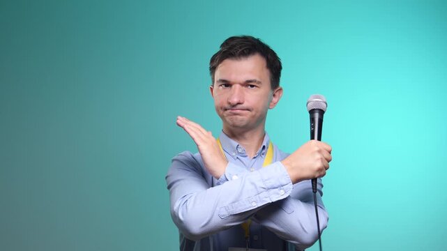 Man holding a microphone and making a stop gesture with his hand, communicating refusal, censorship, or a restriction on expression and freedom of speech