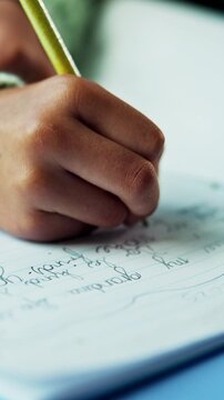 Hands, writing and child with homework in house for education, learning or practicing cursive. Book, student and kid studying for english subject with assignment, assessment or task in apartment.
