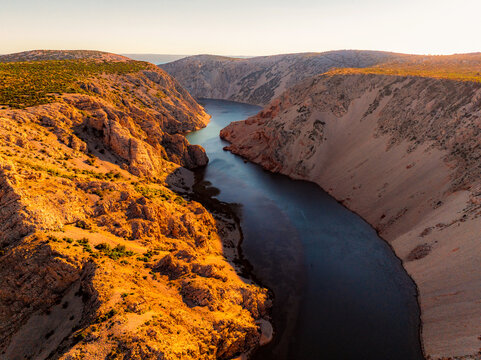 View of the Zrmanja River Canyon in Croatia, with winding turquoise waters cutting through limestone cliffs. A scenic natural wonder popular for kayaking and hiking