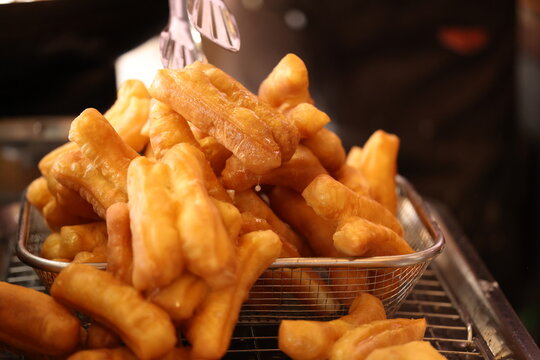 Golden Fried Dough Sticks in Metal Basket at Street Market