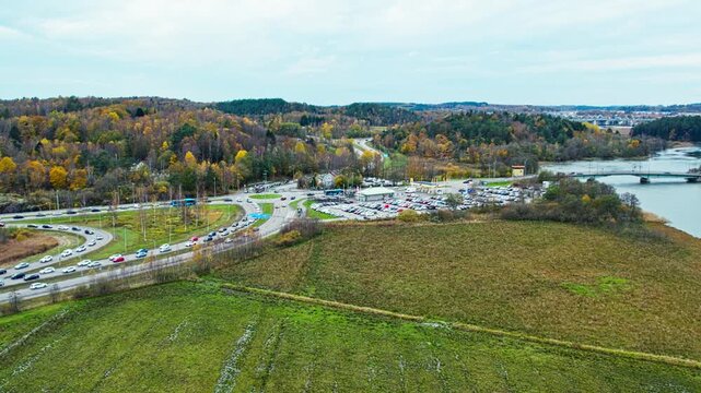 Rush hour near Vikingagrillen fast food restaurant and Jordfallsbron bridge, connecting E45 and E6. This aerial drone view captures the traffic flow and the surrounding Swedish autumn landscape.