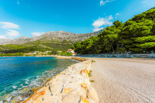 Stunning pebble beach in Drvenik with crystal clear turquoise water and the Biokovo mountain in the Makarska Riviera, Croatia.
