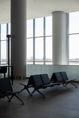 Fototapeta premium Waiting area with black seats in an International airport terminal