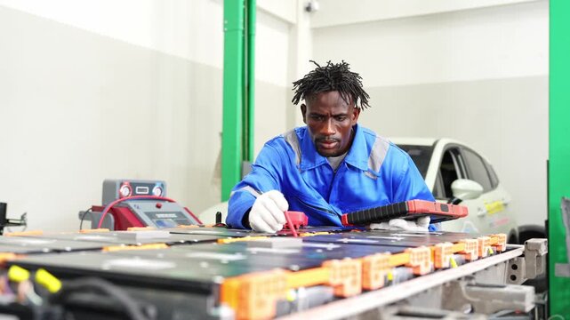 Dedicated technician examining electronic components using a multimeter in a professional workshop environment