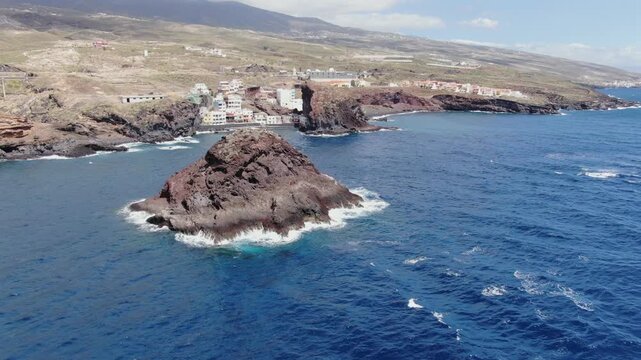 Scenic aerial view of the volcanic coastline of Tenerife, featuring the small village of Los Roques and the iconic sea stack in Fasnia