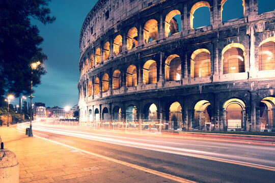 The Colosseum illuminated at dusk with car light trails, Rome, Italy
