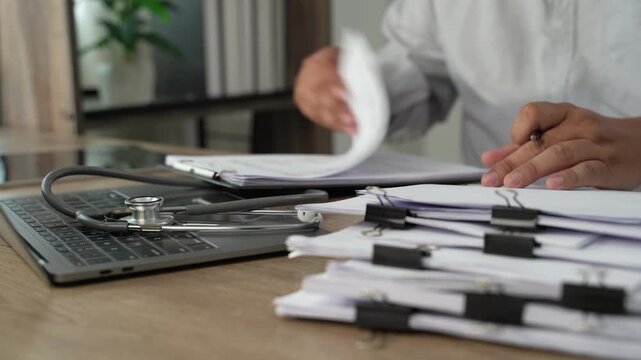Project management  person using a calculator while reviewing printed documents on a desk, showing calculation and document checking for accounting, expense review, and financial reporting.