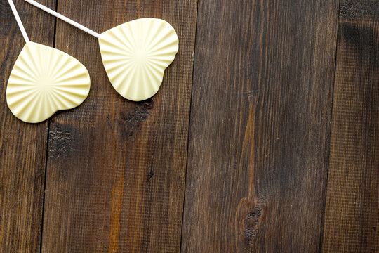Heart-shaped lollipop for Valentine's day on dark wooden background top view copy space