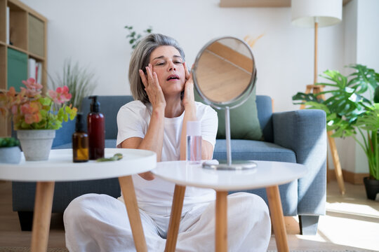 Woman practicing face massage and skincare routine at home