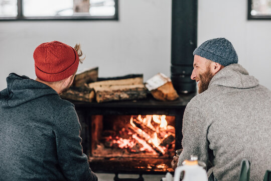 Two men sitting at fireplace