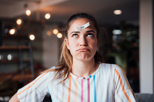 Businesswoman with to do list paper on head in office