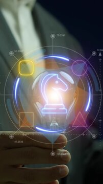 Cropped vertical shot of businessman's open hand holding chess knight inside glowing geometric shapes icon. Neon blue and orange lighting theme, strategic planning and abstract business model concept.