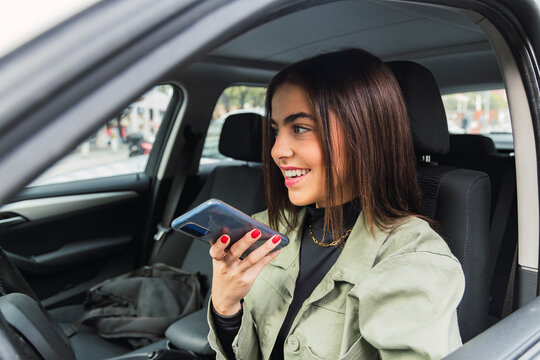 Woman sending voicemail through smart phone in car