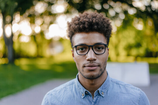 Portrait of young man wearing glasses in park